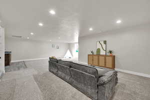 Living room with recessed lighting, light carpet, and a textured ceiling