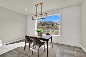 Dining area with wood finished floors, a chandelier, and recessed lighting
