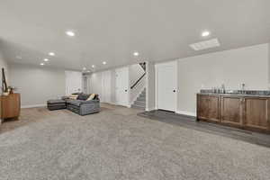 Living area featuring recessed lighting, light carpet, and stairway
