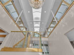 Staircase with a chandelier, recessed lighting, and a high ceiling