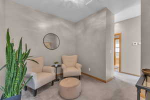 Sitting room featuring carpet floors and baseboards
