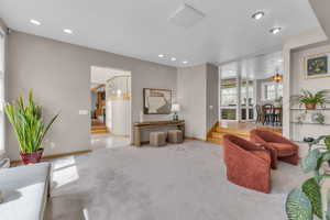 Carpeted living room featuring recessed lighting, stairway, and a baseboard radiator