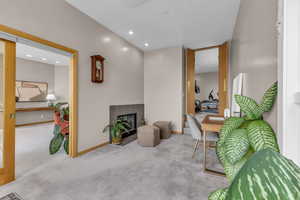 Sitting room with a fireplace, carpet flooring, and recessed lighting
