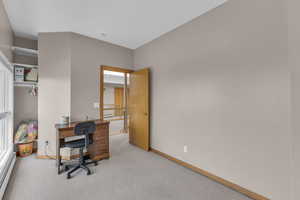 Office area with a baseboard heating unit and carpet floors