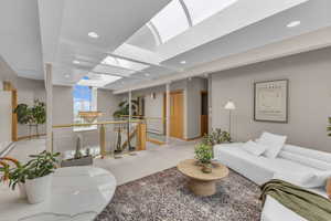 Carpeted living room featuring a skylight and recessed lighting