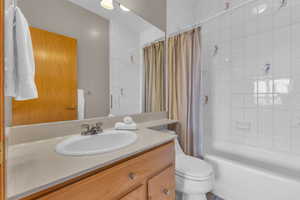 Bathroom with shower / bath combination with curtain and vanity