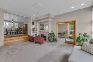 Living room featuring carpet, plenty of natural light, recessed lighting, and a glass covered fireplace