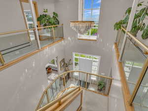 Stairs with a high ceiling, a baseboard heating unit, and carpet flooring