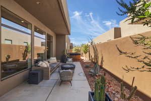 Fenced backyard with a hot tub, a patio area, and an outdoor living space