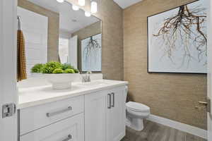 Half bathroom with vanity and dark wood-style flooring