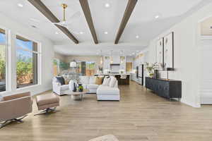 Living room with recessed lighting, beam ceiling, light wood-style flooring, and ceiling fan
