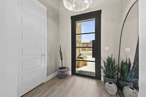 Foyer entrance with light wood-style flooring and baseboards