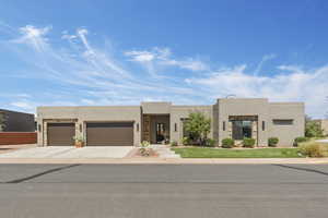 Pueblo-style home with stucco siding, concrete driveway, and a garage