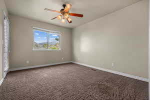 Unfurnished bedroom featuring carpet flooring and ceiling fan