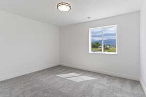 Empty room with a mountain view and light colored carpet
