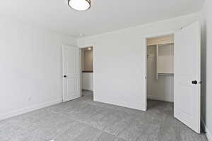 Unfurnished bedroom with carpet floors and a spacious closet