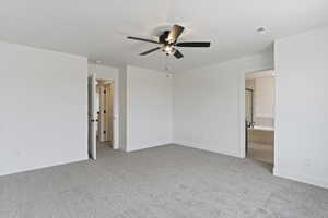 Unfurnished bedroom featuring light colored carpet, a ceiling fan, and ensuite bathroom