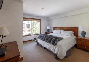 Carpeted bedroom featuring baseboard heating and baseboards
