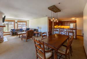 Dining space featuring light colored carpet and a chandelier