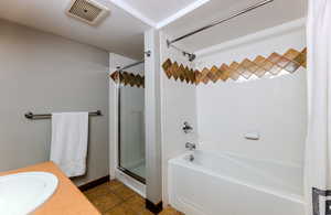 Full bathroom featuring dark tile patterned floors, vanity, and shower / tub combo