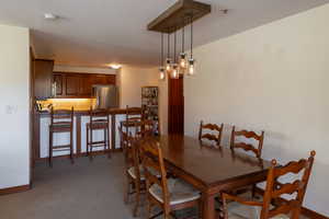 Dining area with baseboards and dark carpet