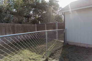 View of fenced backyard & gated dog area