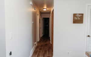 Hallway featuring baseboards and laminate flooring