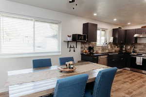 Updated kitchen, stainless steel appliances, butcher block countertops, decorative backsplash, laminate flooring, and under cabinet range hood