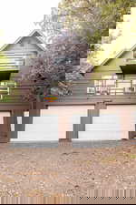 View of front facade with a balcony, driveway, and a garage