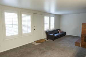 Carpeted entrance foyer with baseboards and a fireplace