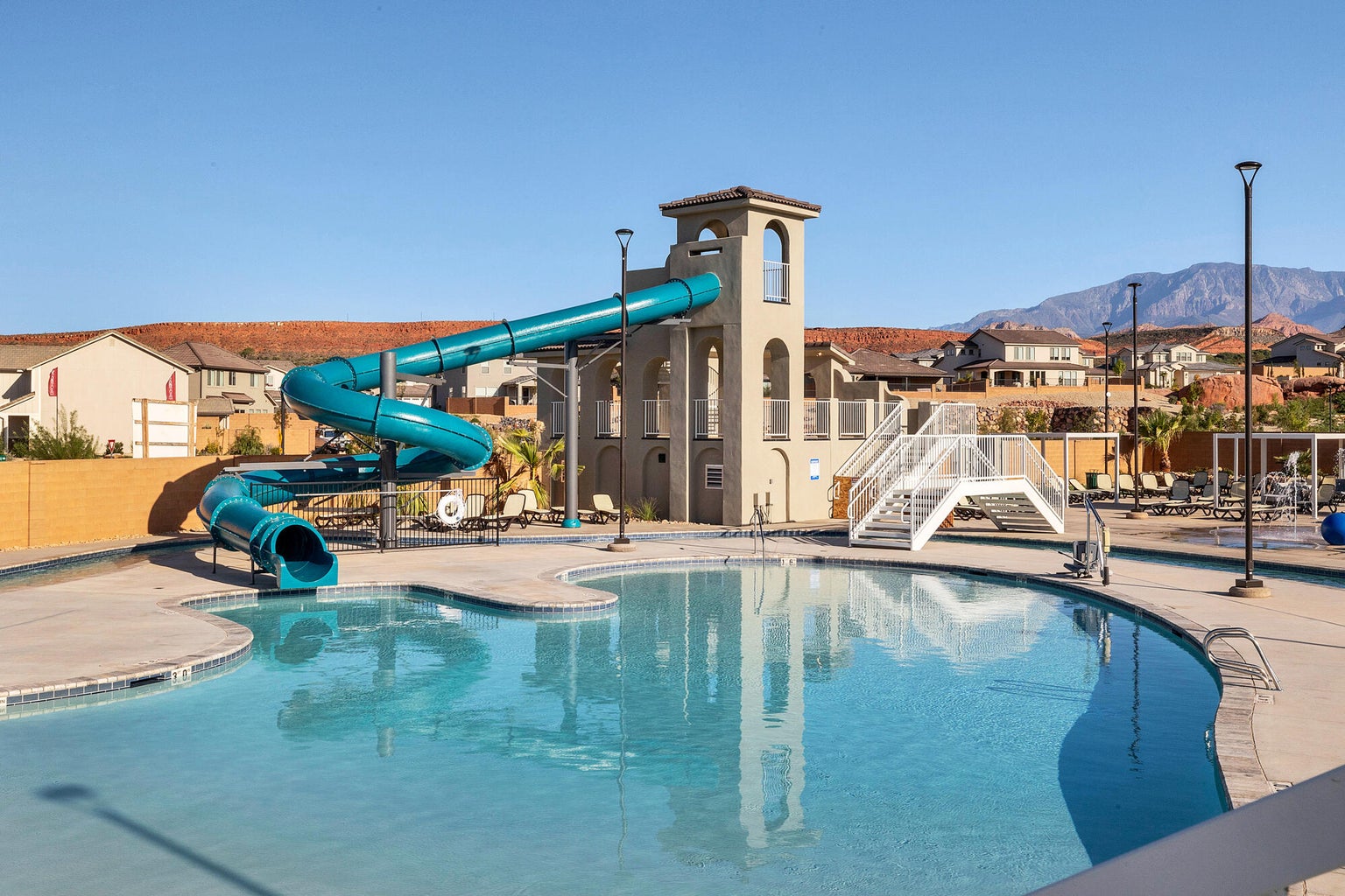 Community pool with a water slide, a residential view, a mountain view, and a patio area