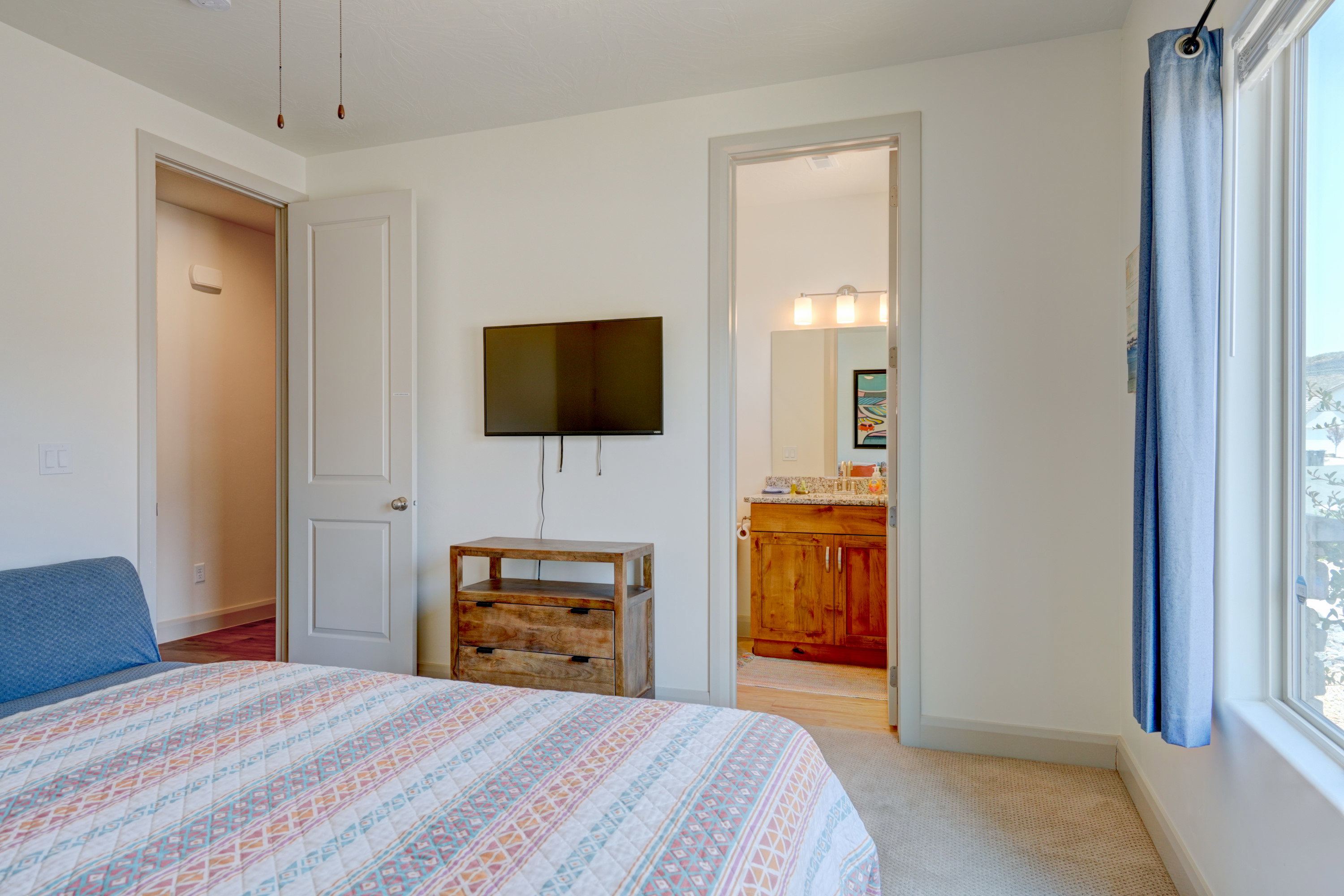 Bedroom with multiple windows, light carpet, and ensuite bathroom