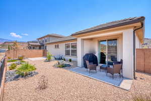 Back of house with stucco siding, a patio, and a fenced backyard