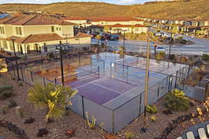 View of tennis court featuring a mountain view, a residential view, and a patio area