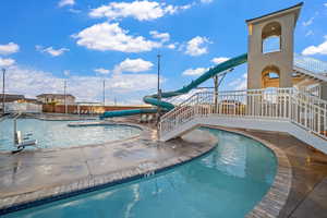 Community pool featuring a patio area and a water slide