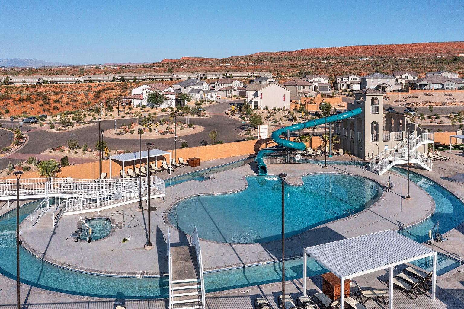 Community pool featuring a water slide, a patio, and a residential view
