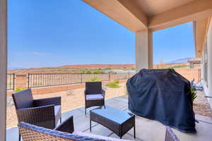 Fenced backyard featuring a patio, grilling area, and a mountain view