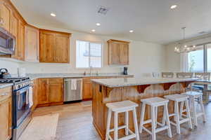 Kitchen featuring stainless steel appliances, recessed lighting, a kitchen breakfast bar, a kitchen island, and a chandelier