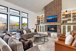 Living room featuring a brick fireplace and high vaulted ceiling