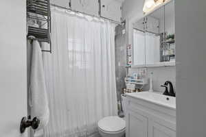 Bathroom with vanity, radiator heating unit, and shower / tub combo