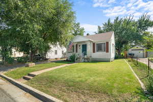 Bungalow-style home with a garage, a chimney, and a shingled roof