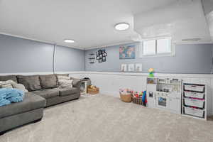 Living area with carpet and a wainscoted wall