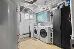 Washroom featuring water heater and washer and dryer