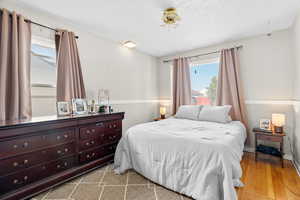 Bedroom with hardwood / wood-style flooring and a textured ceiling