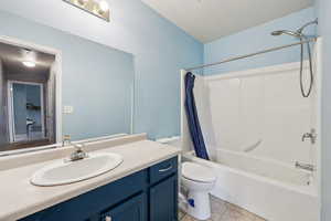 Full bath featuring shower / tub combo with curtain, vanity, and light tile patterned floors