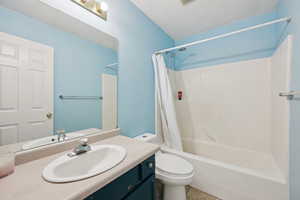 Full bath featuring shower / bath combo, vanity, and light tile patterned flooring
