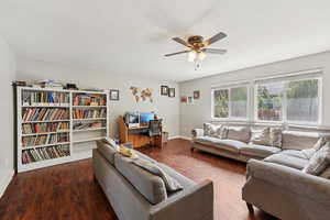 Living room with dark wood finished floors and a ceiling fan