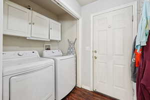 Laundry room featuring cabinet space, independent washer and dryer, and dark wood-style floors