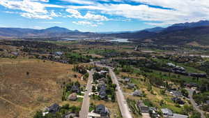 Aerial overview of property's location featuring a water and mountain view and nearby suburban area
