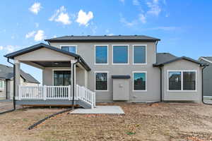 Rear view of property featuring a patio area, a wooden deck, and stucco siding